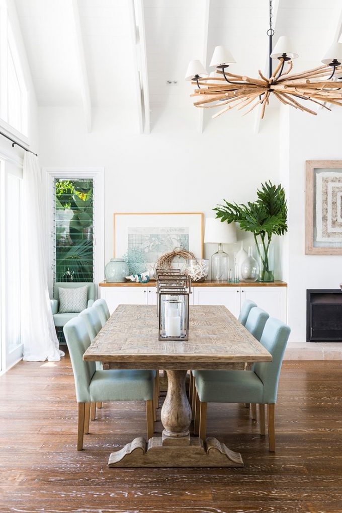 Cozy Laminate Wood Flooring With Elegant Dining Furniture Sets By Seaside Furniture And Crown Chandelier Plus Fireplace Design
